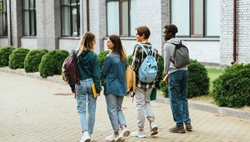 42823841 Back View Of Smiling Teenagers With Backpacks Walking On