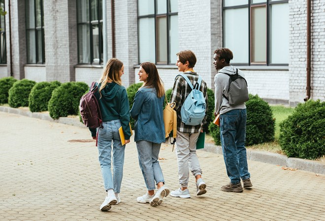 42823841 Back View Of Smiling Teenagers With Backpacks Walking On